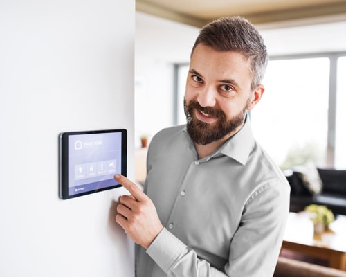 man using his touch screen automation system on the wall to set his security preferences