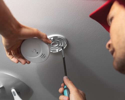 technician installing smoke detector